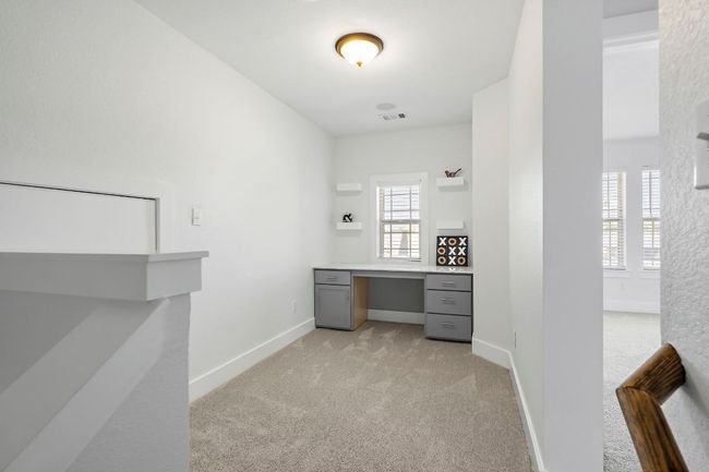 Unfurnished office with visible vents, baseboards, built in study area, and light carpet | Image 23