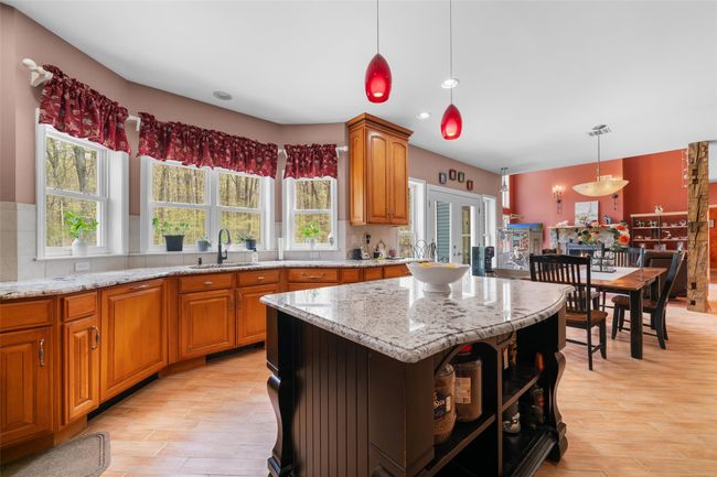 Kitchen featuring open shelves, light stone countertops, light wood-type flooring, a sink, and backsplash | Image 7