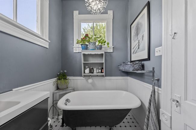 Full bathroom with a soaking tub, a wainscoted wall, vanity, and a chandelier | Image 27