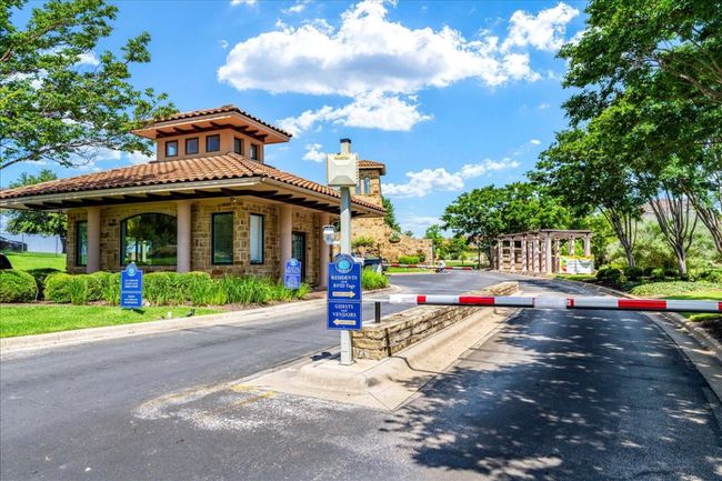 View of asphalt street featuring curbs and a gated entry | Image 37