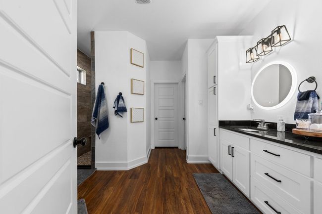 Bathroom with walk in shower, vanity, wood finished floors, and baseboards | Image 20