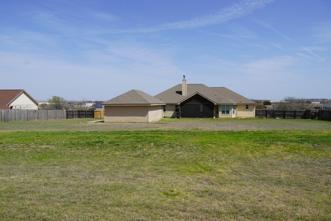 Rear view of house featuring a yard, a chimney, and fence | Image 21