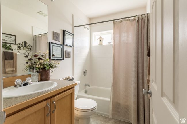Full bath featuring shower / bathtub combination with curtain, visible vents, toilet, and vanity | Image 4