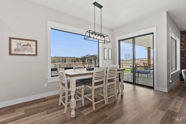 Dining area featuring dark wood-style floors and a chandelier | Image 17