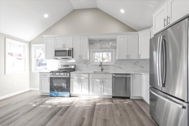 Kitchen with white cabinets, light wood-type flooring, sink, and appliances with stainless steel finishes | Image 6