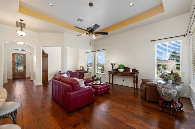 Living room with dark wood-style flooring, plenty of natural light, arched walkways, and recessed lighting | Image 8