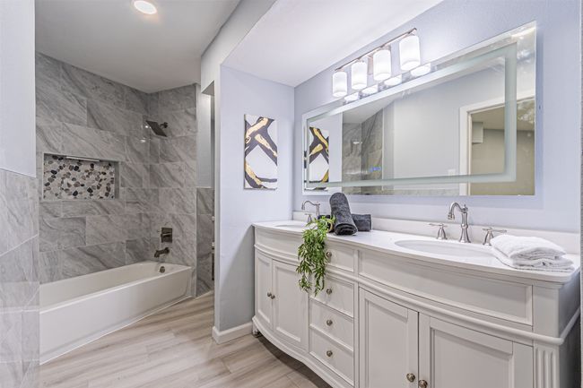 Bathroom featuring a sink, wood finished floors, double vanity, and shower / washtub combination | Image 15