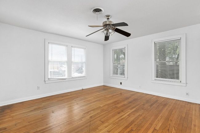 Unfurnished room featuring light wood-type flooring, baseboards, a ceiling fan, and visible vents | Image 34