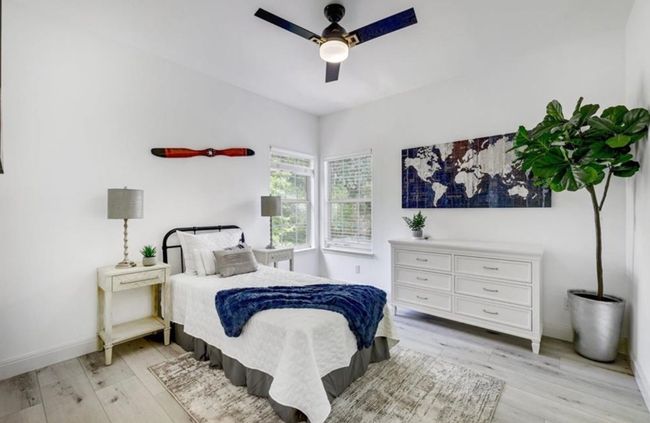 Bedroom with baseboards, light wood finished floors, and ceiling fan | Image 22