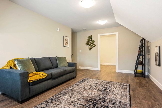 Living area featuring baseboards, lofted ceiling, and dark wood-type flooring | Image 26
