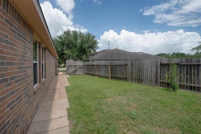 A view along the side of the home with pathway to the gate and front yard. | Image 35