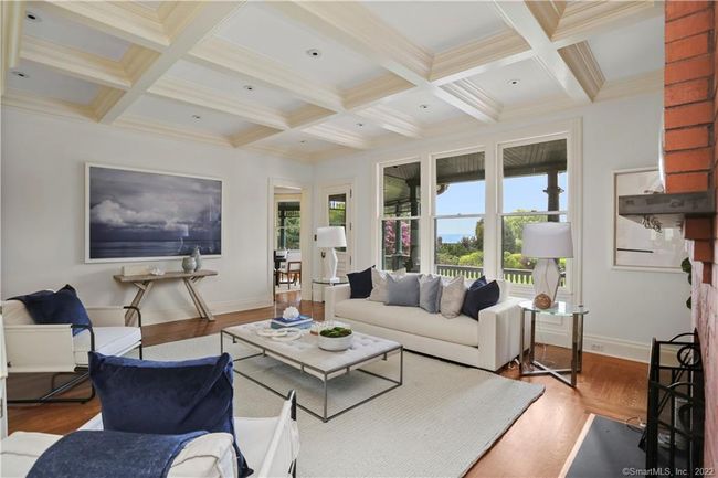 FAMILY ROOM // Adjacent to kitchen, coffered Poplar ceiling, wood burning fireplace with gas assist, built-ins and access to veranda with mahogany floor and screened porch. | Image 11