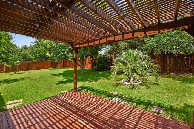 Step outside to your private backyard haven, where a pergola-covered deck and patio create the ideal setting for al fresco dining, morning coffee, or relaxing under the Texas sky. | Image 35