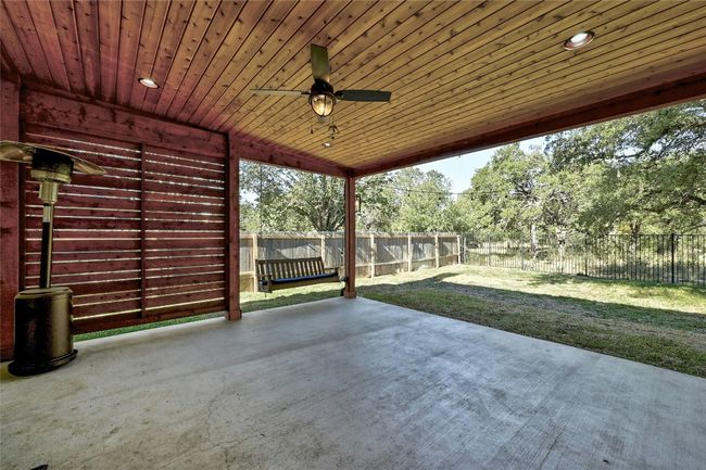 Fenced backyard with a patio area and a ceiling fan | Image 26