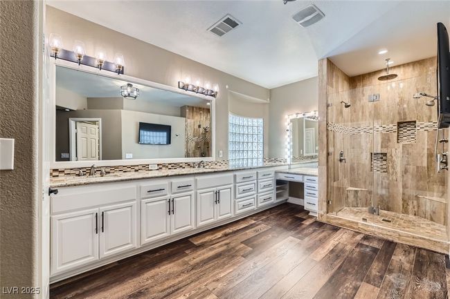 Bathroom featuring double vanity, a stall shower, and wood finished floors | Image 21