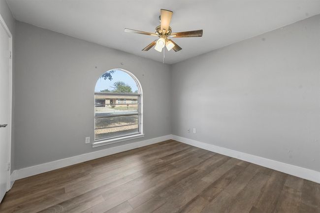 Spare room featuring ceiling fan and dark wood-type flooring | Image 25