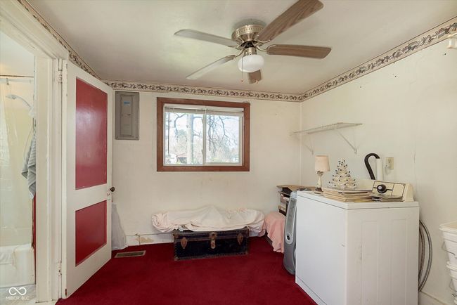 laundry area featuring laundry area, a ceiling fan, visible vents, electric panel, and carpet flooring | Image 28