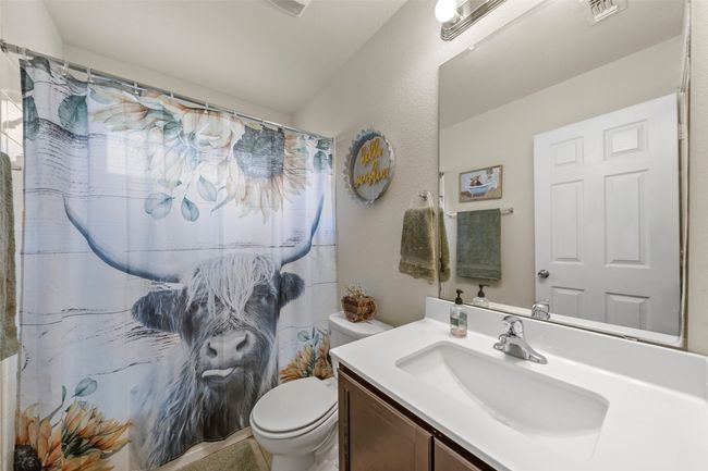 Bathroom featuring vanity and curtained shower | Image 10