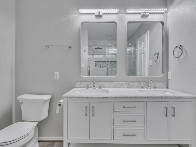 Full bath featuring toilet, a stall shower, and double vanity | Image 19