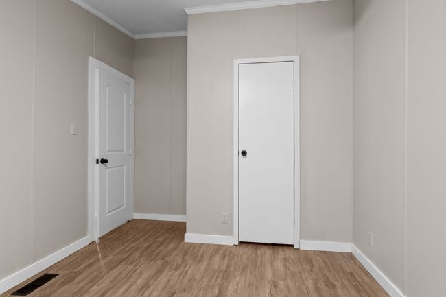 Unfurnished bedroom featuring light wood finished floors and crown molding | Image 27
