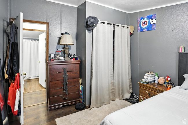 Bedroom with wood finished floors and a textured wall | Image 15