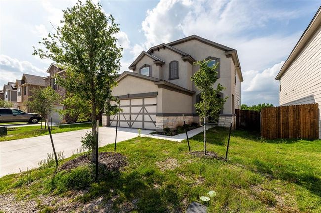View of front of home featuring concrete driveway, stone siding, an attached garage, and stucco siding | Image 29