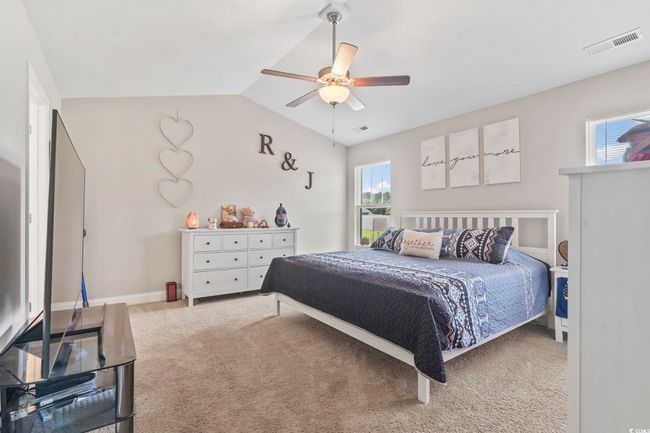 Carpeted bedroom with vaulted ceiling and a ceiling fan | Image 22