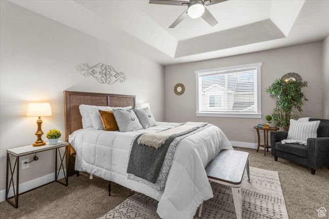 Bedroom featuring a tray ceiling, carpet flooring, baseboards, and a ceiling fan | Image 19