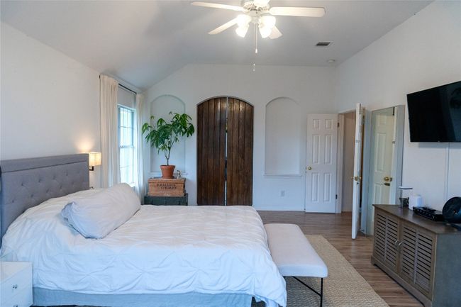Bedroom with light wood-type flooring, lofted ceiling, and ceiling fan | Image 32