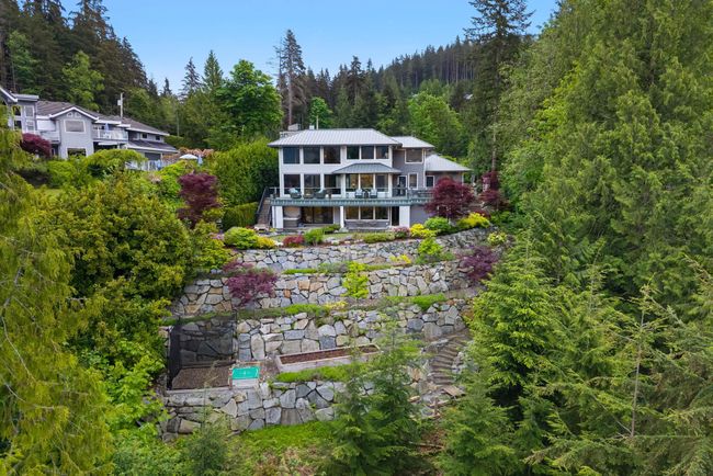 Back of property with a wooded view, metal roof, stairway, and a deck | Image 38