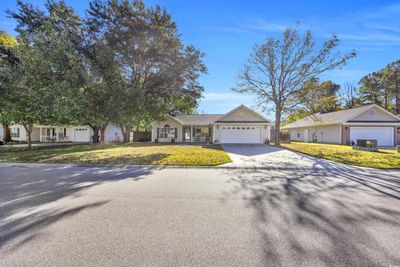 Single story home with a front lawn and covered porch | Image 1