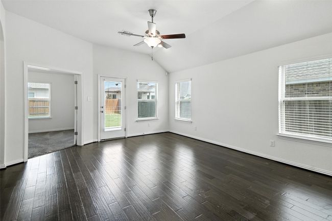 Unfurnished room featuring ceiling fan, vaulted ceiling, and dark wood-style flooring | Image 21