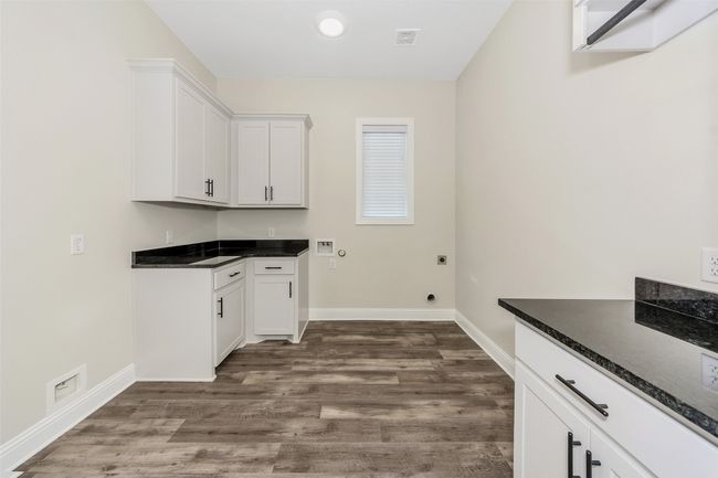 Laundry room featuring baseboards, hookup for a washing machine, cabinet space, electric dryer hookup, and dark wood-style flooring | Image 33
