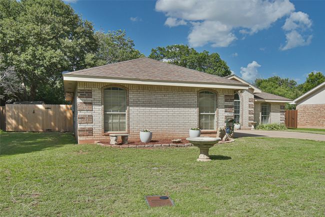Ranch-style home featuring a shingled roof and brick siding | Image 39
