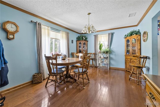 Dining area featuring dark wood-style flooring, a wealth of natural light, and a notable chandelier | Image 20