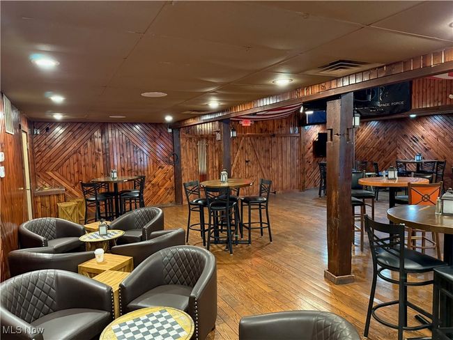 Bar area featuring wood walls and hardwood / wood-style flooring | Image 12
