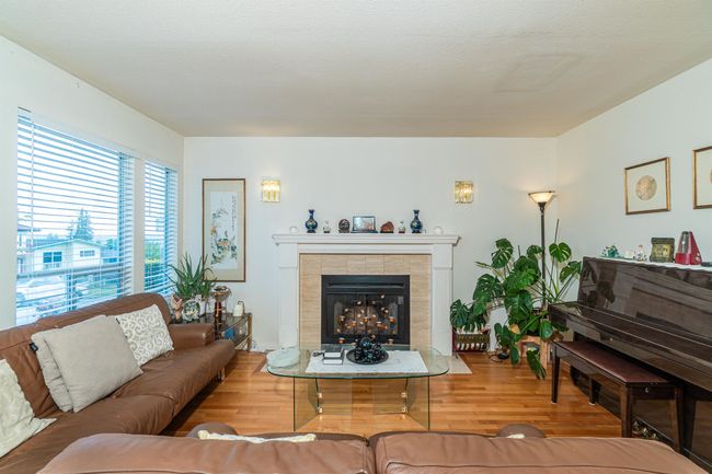 Living area with a tile fireplace and wood finished floors | Image 5