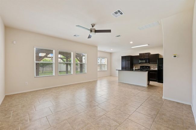 Unfurnished living room featuring light tile patterned flooring, a ceiling fan, baseboards, and recessed lighting | Image 13