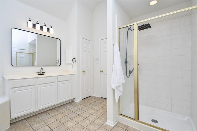Your oasis of a primary bathroom! Measuring 13' x 14', it is complete with a stand-up shower with tile-surround and a spacious vanity area to help with your morning and evening routines. | Image 18
