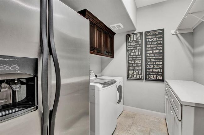 Spacious laundry room with extra built-in cabinets and counters, plus room for an extra fridge. | Image 25