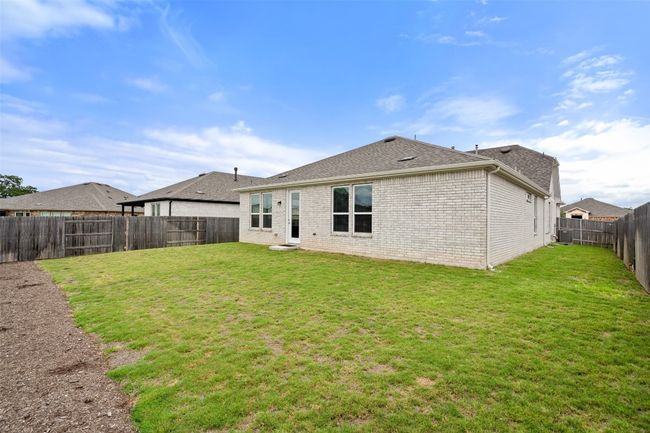 Rear view of property featuring brick siding and large backyard. | Image 30