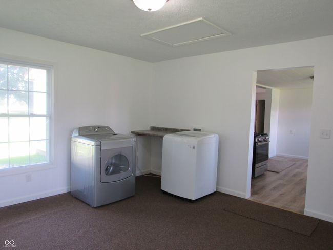 laundry area within a large bonus room and plenty of natural light | Image 14