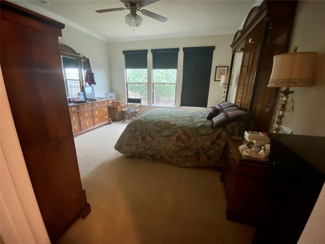 Carpeted bedroom with crown molding and a ceiling fan | Image 10
