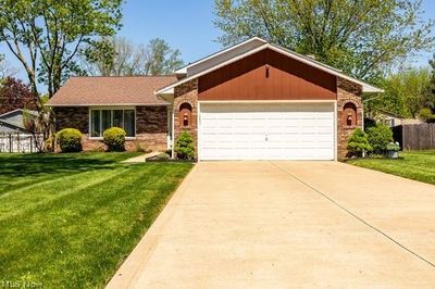 Ranch-style home with a front yard and a garage | Image 1