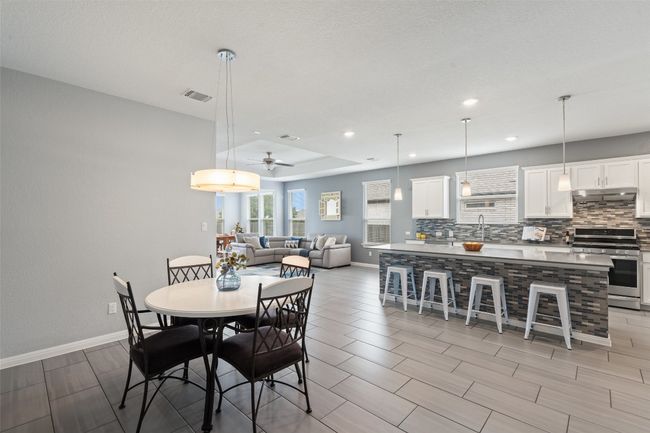 Dining room with baseboards, tile floors, chandelier, and recessed lighting. | Image 7