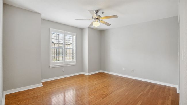 Empty room with hardwood / wood-style floors, a ceiling fan, and baseboards | Image 8