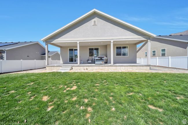 Rear view of property featuring stucco siding, fence, a patio area, and a yard | Image 26