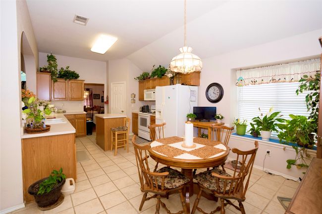 Dining space with light tile patterned floors, vaulted ceiling, and arched walkways | Image 15
