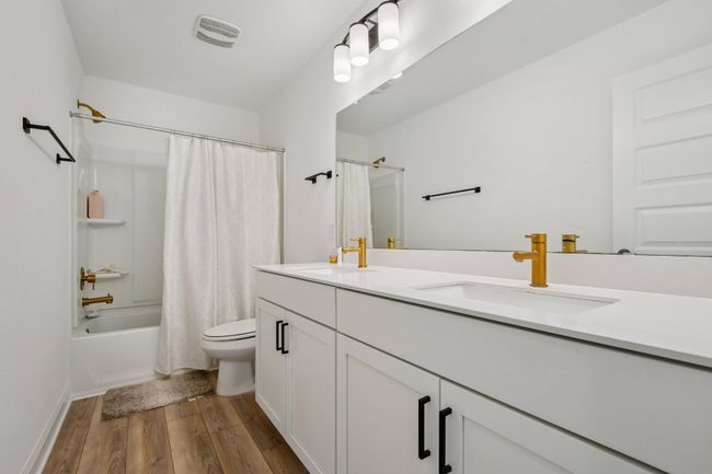Bathroom with wood finished floors, double vanity, and shower / bath combo | Image 23