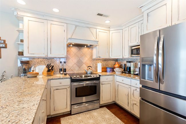 Kitchen featuring appliances with stainless steel finishes, backsplash, premium range hood, open shelves, and recessed lighting | Image 51